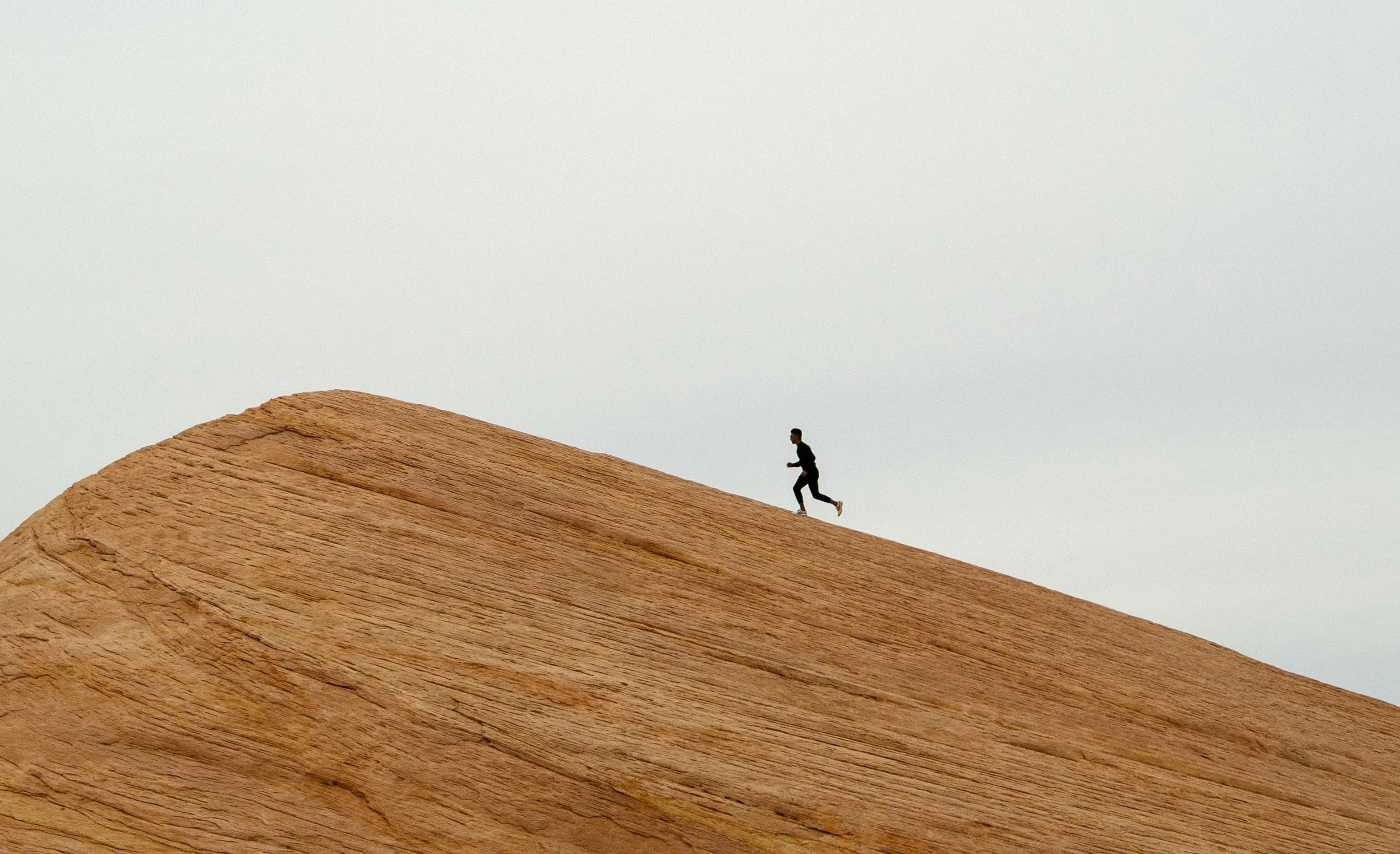 Two hikers on a ridgeline above the clouds